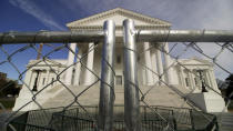 The Virginia state Capitol building is surrounded by fencing, Thursday, Jan. 16, 2020 in Richmond, Va., in preparation for Monday's rally by gun rights advocates. Gun-rights groups are asking a judge to block the Virginia governor's ban on firearms at a massive pro-gun rally scheduled for next week. Gov. Ralph Northam on Wednesday, Jan. 15, announced a state of emergency and banned all weapons from the rally at the Capitol. (Dean Hoffmeyer/Richmond Times-Dispatch via AP)