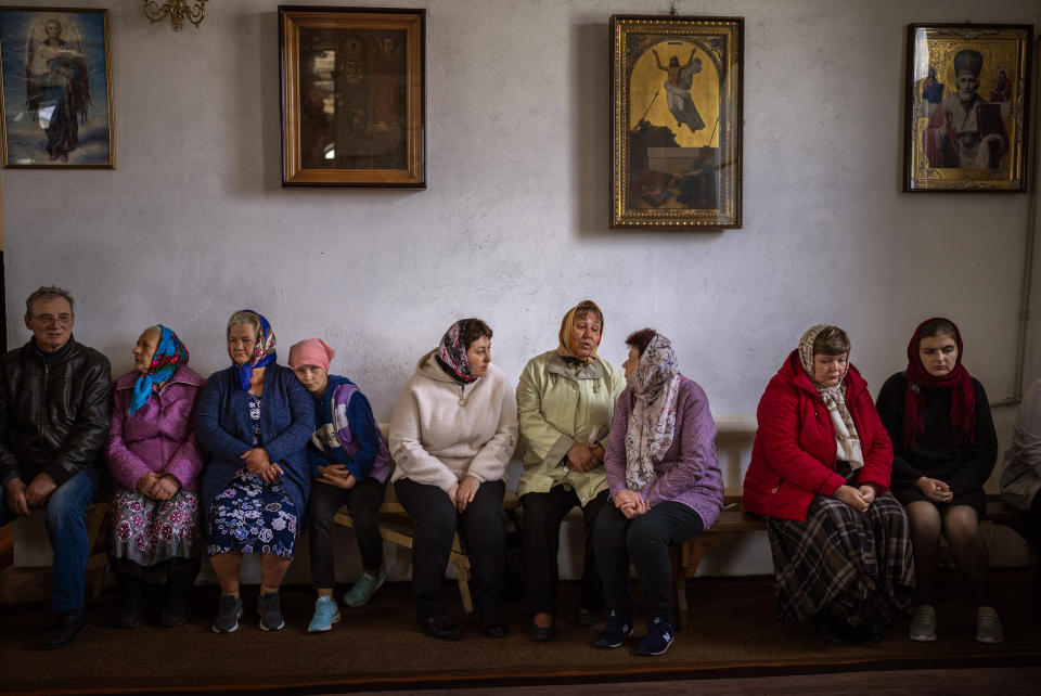 Ukraine women wait for the start of a religious service to commemorate the fallen during the Russian occupation in Zdvyzhivka, on the outskirts of Kyiv, on Saturday, April 30, 2022. (AP Photo/Emilio Morenatti)