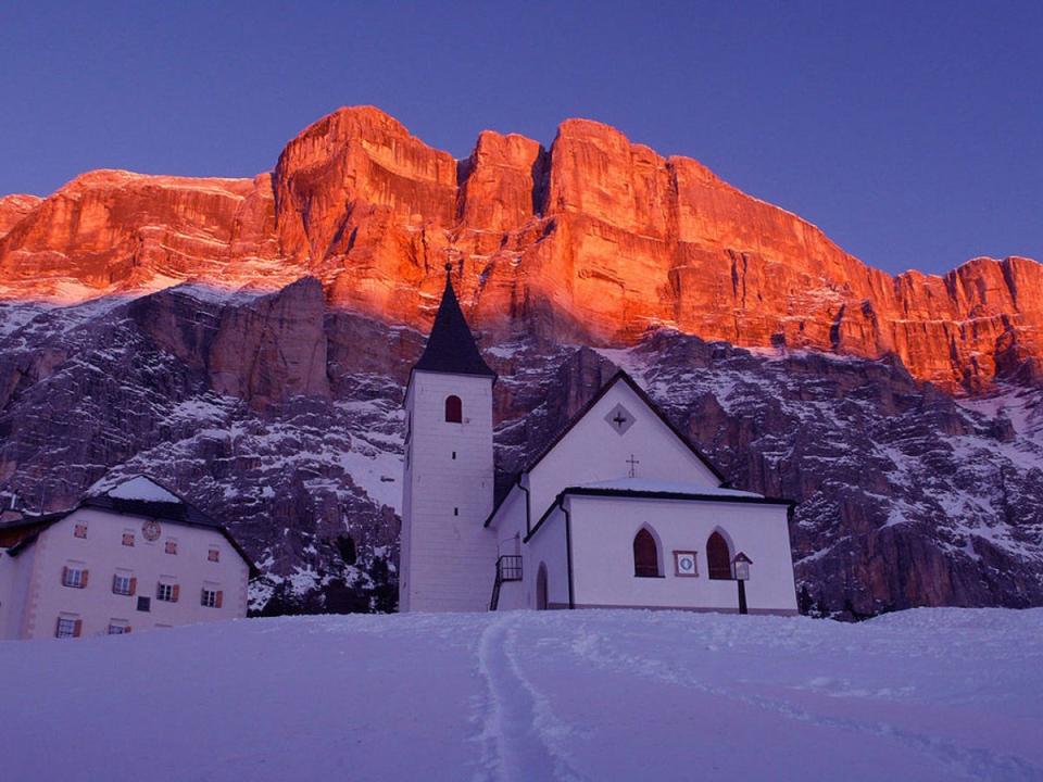 Unlike the grayscale Alps, the Dolomites have a distinctly yellow, sun-kissed hue, even when not being hit by the a sunset (Hotel Sassongher)