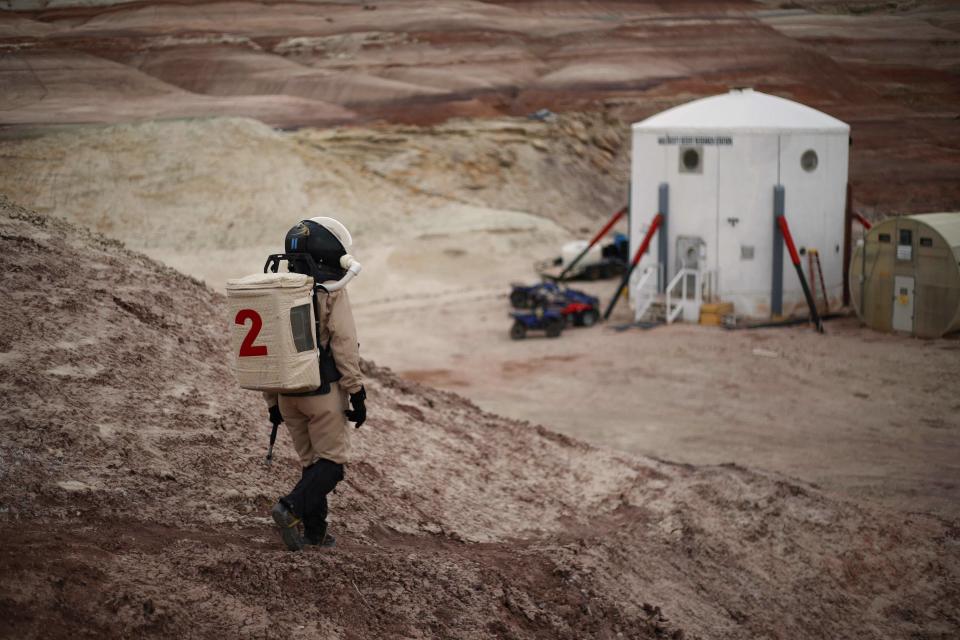 Csilla Orgel, a geologist of Crew 125 EuroMoonMars B mission, makes her way back to the Mars Desert Research Station (MDRS) in the Utah desert March 3, 2013. The MDRS aims to investigate the feasibility of a human exploration of Mars and uses the Utah desert's Mars-like terrain to simulate working conditions on the red planet. Scientists, students and enthusiasts work together developing field tactics and studying the terrain. All outdoor exploration is done wearing simulated spacesuits and carrying air supply packs and crews live together in a small communication base with limited amounts of electricity, food, oxygen and water. Everything needed to survive must be produced, fixed and replaced on site. Picture taken March 3, 2013. REUTERS/Jim Urquhart
