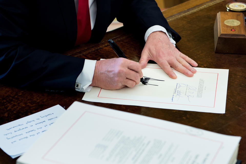 President Donald Trump signs the Tax Cut and Reform Bill in the Oval Office at The White House on Dec. 22, 2017. | Brendan Smialowski—AFP/Getty Images