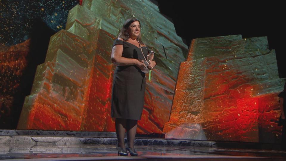 Vianne Timmons holds an eagle feather — a gift from a student — while accepting the Indspire Award for education at an award ceremony in 2019. 