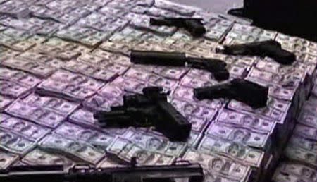 Police pile stacks of money and some weapons after a raid at the home belonging to Chinese businessman Zhenli Ye Gon in Mexico City, Mexico is seen in this still image taken from video, in March 2007. Mexican Attorney General/Handout via REUTERS