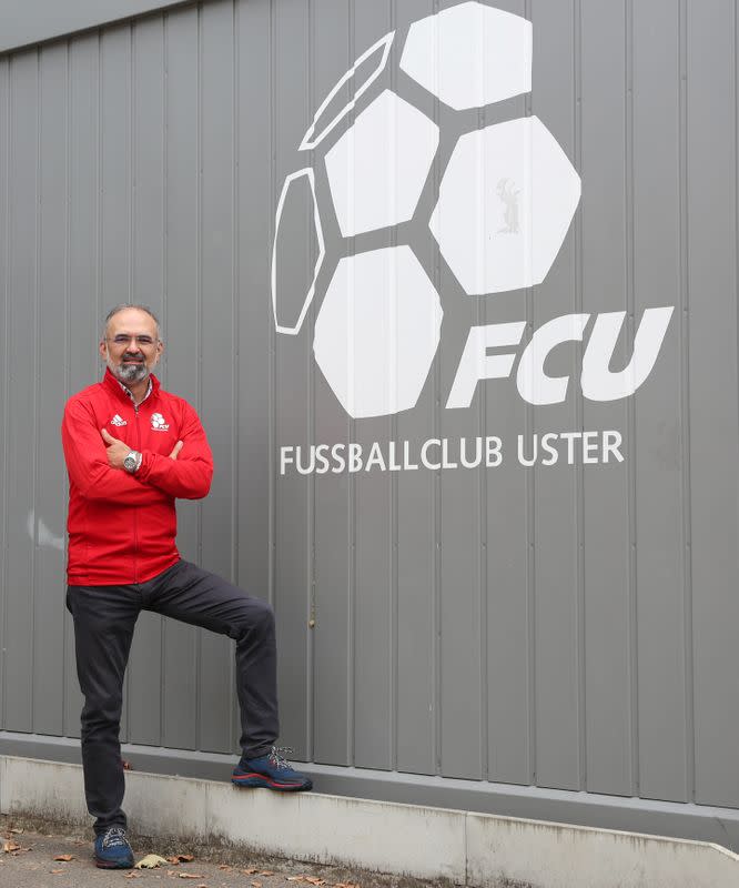 Ali Oezcan, vice-president of Swiss soccer club FC Uster poses in front of club logo in Uster