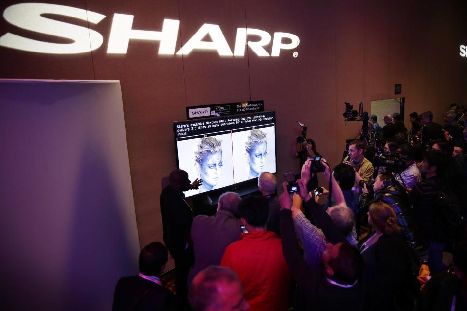 Journalists check out the new Sharp 4K lite television during a news conference at the Consumer Electronics Show press day on Monday, Jan. 6, 2014, in Las Vegas. (AP Photo/Isaac Brekken)