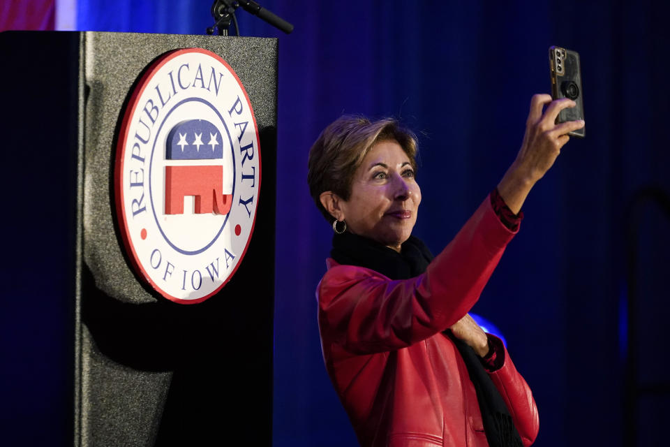 Marni Hockenberg, of Des Moines, Iowa, takes a photo during a Republican Party of Iowa election night rally, Tuesday, Nov. 8, 2022, in Des Moines, Iowa. (AP Photo/Charlie Neibergall)