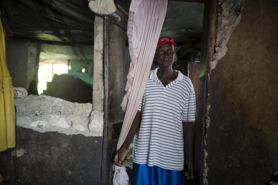 Marcorel Maurice stands inside his home damaged by a magnitude 5.9 earthquake the night before, in Gros Morne, Haiti, Sunday, Oct. 7, 2018. Emergency teams worked to provide relief in Haiti on Sunday after the quake killed at least 11 people and left dozens injured. ( AP Photo/Dieu Nalio Chery)