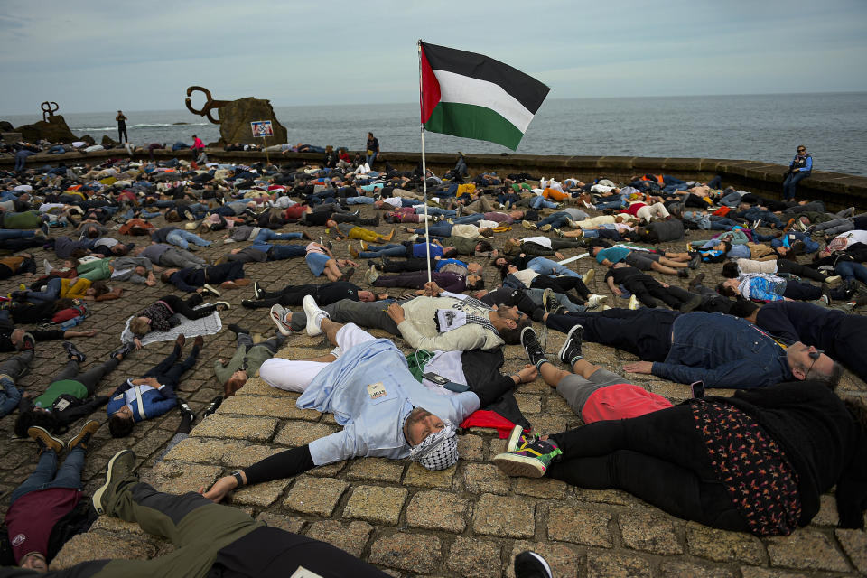 Pro-Palestinian demonstrators lie on the ground as they protest against Israeli attacks on Gaza, in San Sebastian, northern Spain, on Sunday, March 17, 2024. (AP Photo/Alvaro Barrientos)
