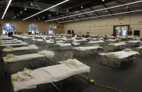 Cots are set up at a possible COVID-19 treatment site Wednesday, April 1, 2020, in San Mateo, Calif. The National Guard is currently setting up the federal cache, which includes cots and personal protective equipment needed to establish a federal medical station with capacity up to 250 beds. No patients will be immediately housed in the space but proactively standing it up now allows the County to be ready if and when hospitals need more medical spaces. (AP Photo/Ben Margot, Pool)