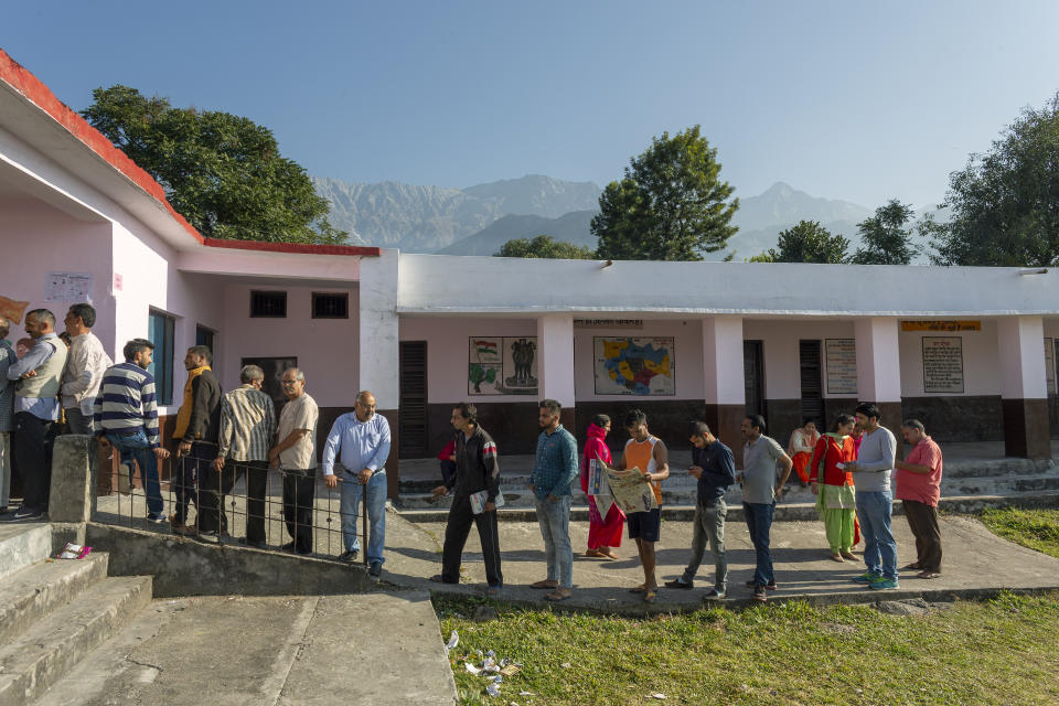 Voters line up outside a polling booth to cast their ballot in a bypoll for an assembly seat in Dharmsala, India, Monday, Oct. 21, 2019. The seat was vacated by Kishan Kapoor, a Bharatiya Janata Party member of legislative assembly , who was elected to the Lok Sabha in May as voting is underway in two Indian states of Maharashtra in the west and Haryana in the north where the Hindu nationalist Bharatiya Janata Party (BJP) headed by prime minister Narendra Modi is trying to win a second consecutive term. (AP Photo/Ashwini Bhatia)