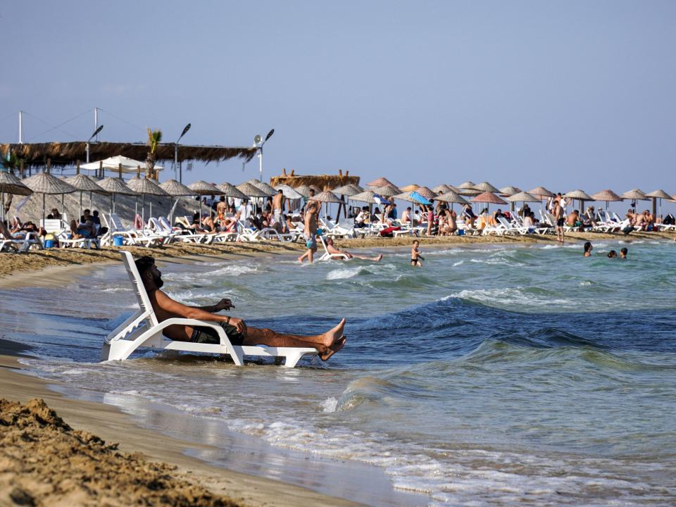 A man lounges on a chair along a beach in Varosha on September 18, 2022