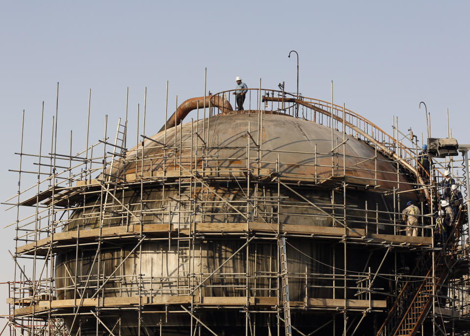 During a trip organized by Saudi information ministry, engineers fix Aramco's oil operator at processing facility after the recent Sept. 14 attack on Aramco's oil processing facility in Abqaiq, near Dammam in the Kingdom's Eastern Province, Friday, Sept. 20, 2019. Saudi Arabia allowed journalists access Friday to the site of a missile-and-drone attack on a facility at the heart of the kingdom's oil industry, an assault that disrupted global energy supplies and further raised tensions between the U.S. and Iran.. (AP Photo/Amr Nabil)