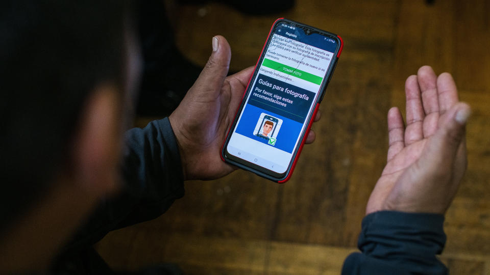 Ecuadorian immigrant Neptali Chiluisa shows the app that he uses for reporting his location to Immigration authorities, during an interview inside his temporary house in the borough of Bronx on Thursday, Oct. 21, 2021, in New York. Nearly six months ago, U.S. immigration courts established a fast-track docket for families who recently crossed the border. They go to the front of the line with the idea that others will be less likely to migrate knowing a backlog of more than 1.4 million cases will no longer buy them at least a few years in the United States. (AP Photo/Eduardo Munoz Alvarez)