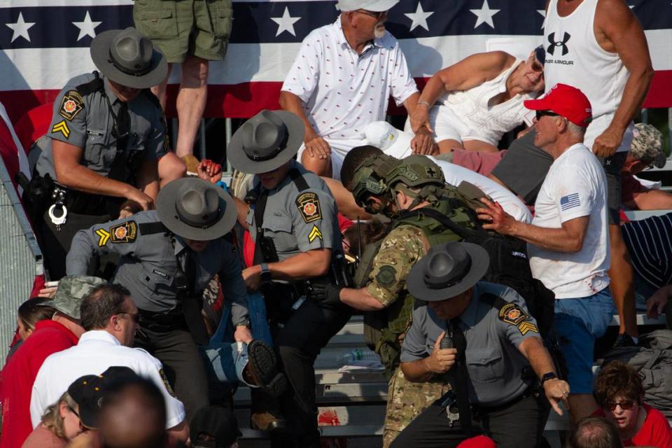 A person is removed by state police from the stands after guns were fired at Republican candidate Donald Trump at a campaign event at Butler Farm Show Inc. in Butler, Pennsylvania, July 13, 2024. The suspected shooter who wounded Republican presidential candidate Donald Trump at a rally is dead, US media reported Saturday, along with one bystander.