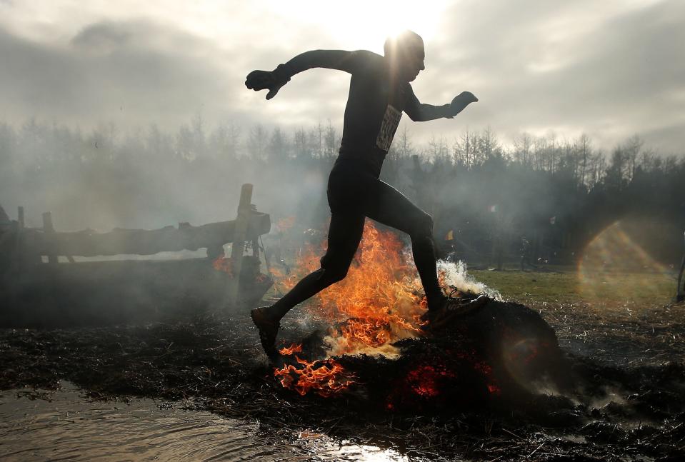 A competitor runs through flames during the Tough Guy event in Perton, central England