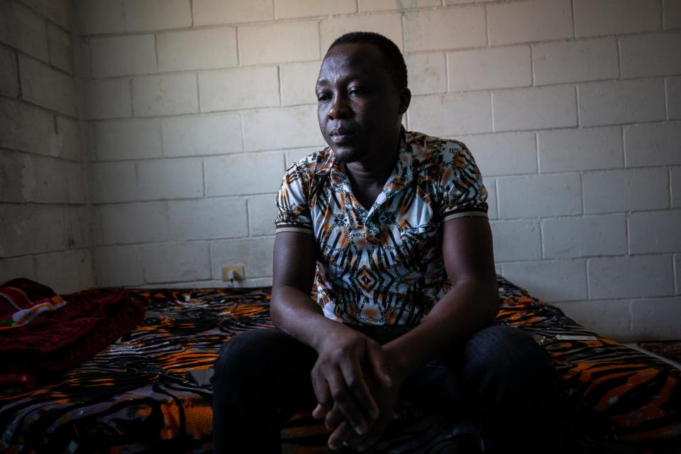 John Lafontant, a 33-year-old Haitian, spent two days underneath the Del Rio, Texas, bridge but left after his family warned him of expulsions of other migrants to Haiti. In this Nov. 13, 2021, photo, he sits inside an apartment in Tijuana.