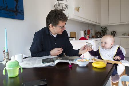 Peter Talos feeds his daughter Karin, as they spend time together during his parental leave, in Oslo, October 5, 2012. REUTERS/Heiko Junge/NTB Scanpix