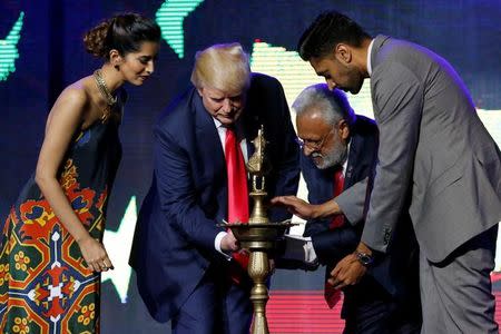 Republican Hindu Coalition Chairman Shalli Kumar (2nd R) helps Republican presidential nominee Donald Trump (2nd L) light a ceremonial diya lamp before he speaks at a Bollywood-themed charity concert put on by the Republican Hindu Coalition in Edison, New Jersey, U.S. October 15, 2016. REUTERS/Jonathan Ernst