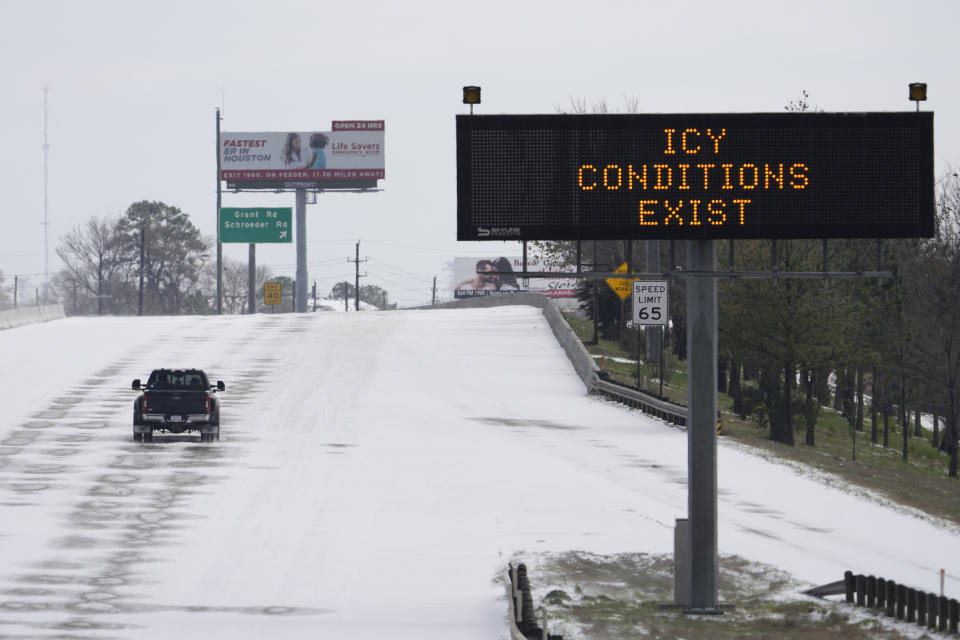 A truck drives past a highway sign Monday, Feb. 15, 2021, in Houston. A frigid blast of winter weather across the U.S. plunged Texas into an unusually icy emergency Monday that knocked out power to more than 2 million people and shut down grocery stores and dangerously snowy roads. (AP Photo/David J. Phillip)