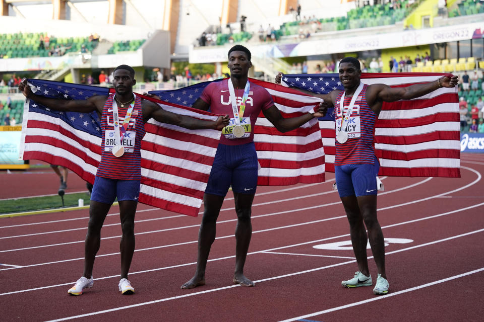 Gold medalist Fred Kerley, of the United States, center, stands with silver medalist Marvin Bracy, of the United States, right, and bronze medalist Trayvon Bromell, of the United States, after the final in the men's 100-meter run at the World Athletics Championships on Saturday, July 16, 2022, in Eugene, Ore. (AP Photo/Ashley Landis)
