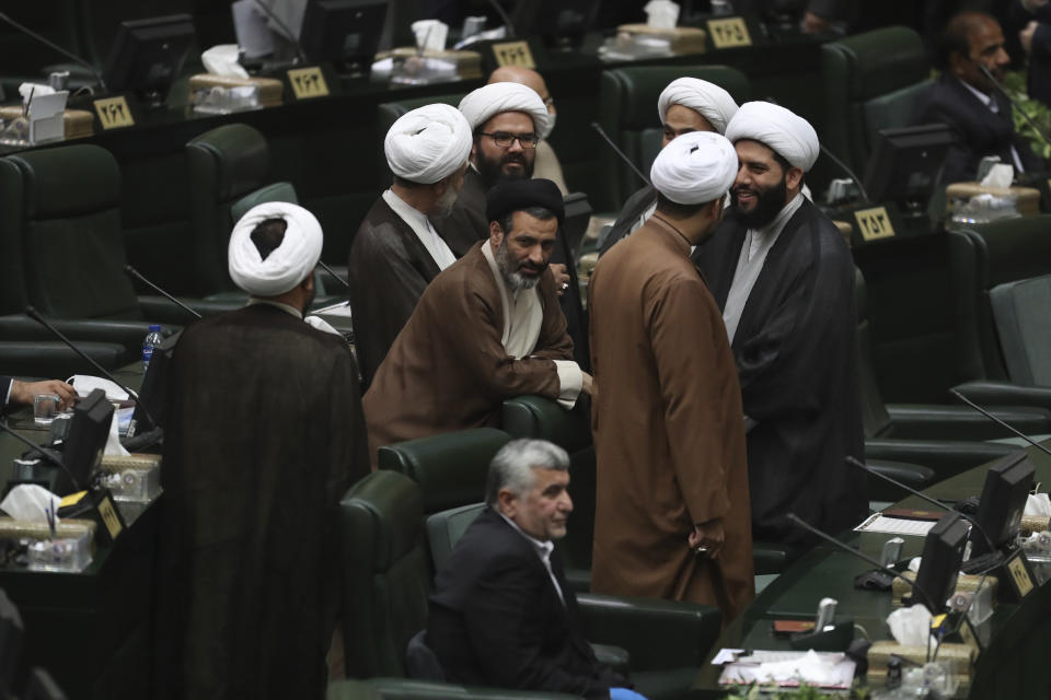A group of cleric lawmakers speak prior to the start of the inauguration ceremony of Iran's new parliament, in Tehran, Iran, Wednesday, May, 27, 2020. Iran convened its newly elected parliament, dominated by conservative lawmakers and under strict social distancing regulations, as the country struggles to curb the spread of coronavirus that has hit the nation hard. Iran is grappling with one of the deadliest outbreaks in the Middle East. (AP Photo/Vahid Salemi)