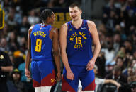 Denver Nuggets forward Peyton Watson, left, jokes with center Nikola Jokic in the second half of an NBA basketball game against the Portland Trail Blazers Friday, Feb. 2, 2024, in Denver. (AP Photo/David Zalubowski)