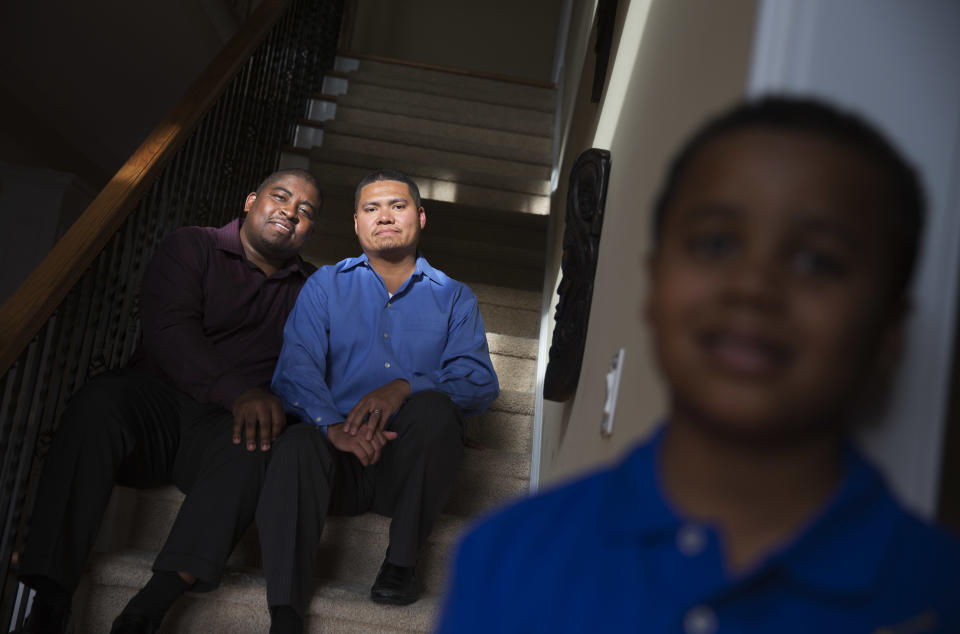 Shelton Stroman, left, sits with partner Christopher Inniss, in their home, as their son Jonathan, 9, looks on at right, Thursday, April 17, 2014, in Snellville, Ga. A gay rights group on Tuesday, April 22, 2014, filed a federal lawsuit in Atlanta challenging the state of Georgia’s constitutional ban on same-sex marriages. (AP Photo/David Goldman)