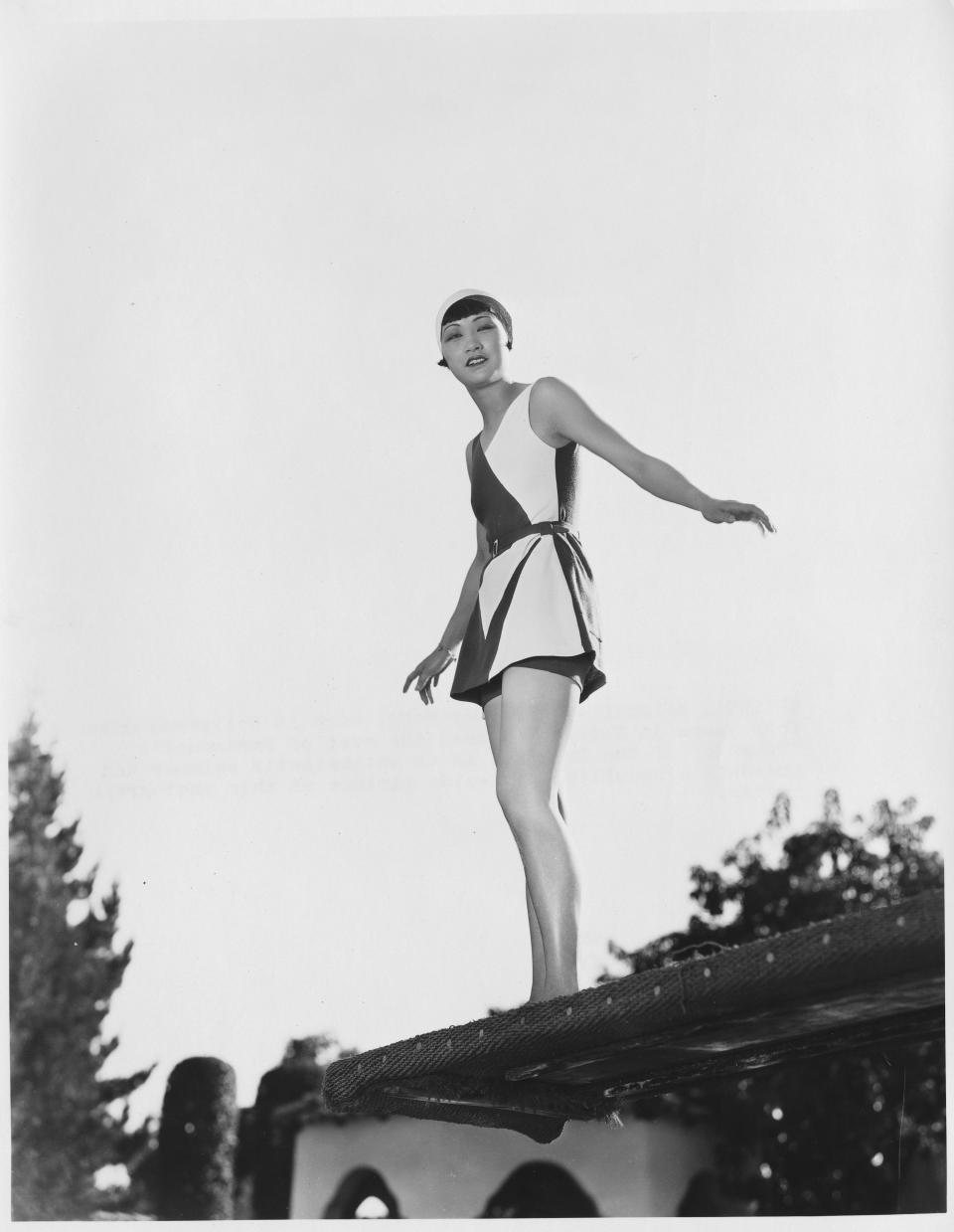 Anna May Wong stands on a roof wearing a black and white ensemble, undated.&nbsp;