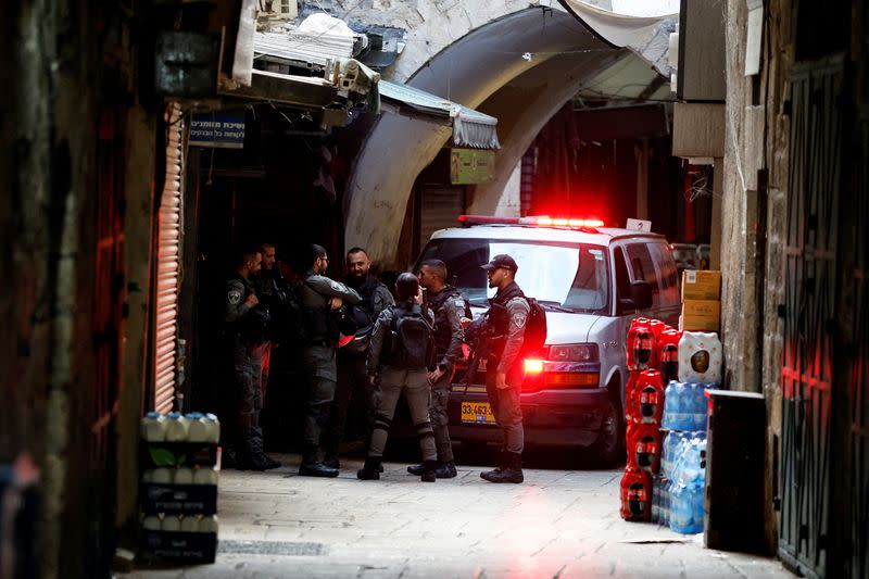 Israeli police stand and talk as they guard the area of a stabbing incident by a Palestinian man in Jerusalem's Old City