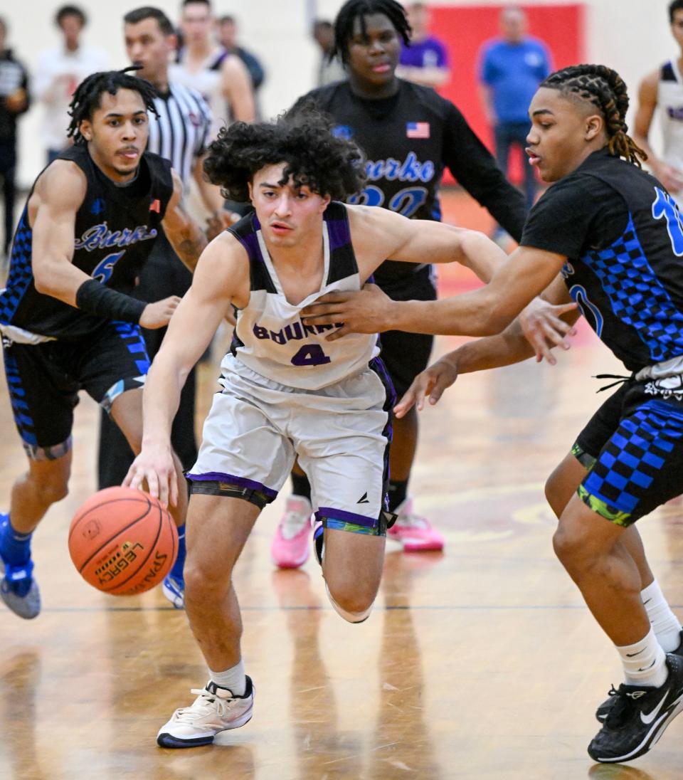 Dom Quelle of Bourne squeezes past Malik Adamson of Jeremiah E. Burke in the boys basketball final four game on March 12 at Bridgewater-Raynham Regional High.