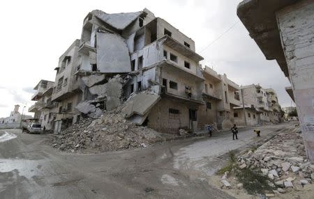 Children play in front of damaged buildings along a deserted street in Maaret al-Naaman town in Idlib province November 27, 2014. REUTERS/Khalil Ashawi