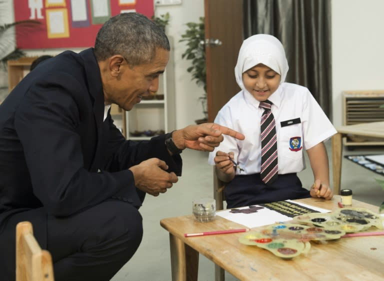 US President Barack Obama speaks with children between the ages of seven and nine as he tours the Dignity for Children Foundation in Kuala Lumpur on November 21, 2015