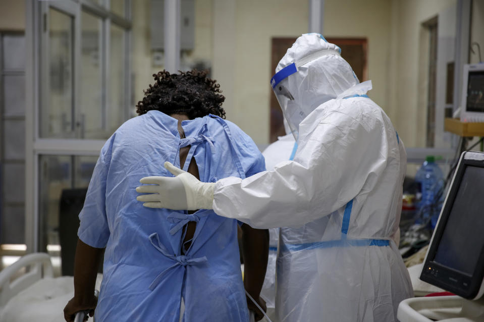 A medical worker attends to a coronavirus patient in the intensive care unit of an isolation and treatment center for those with COVID-19 in Machakos, south of the capital Nairobi, in Kenya Tuesday, Nov. 3, 2020. As Africa is poised to surpass 2 million confirmed coronavirus cases it is Kenya's turn to worry the continent with a second surge in infections well under way. (AP Photo/Brian Inganga)