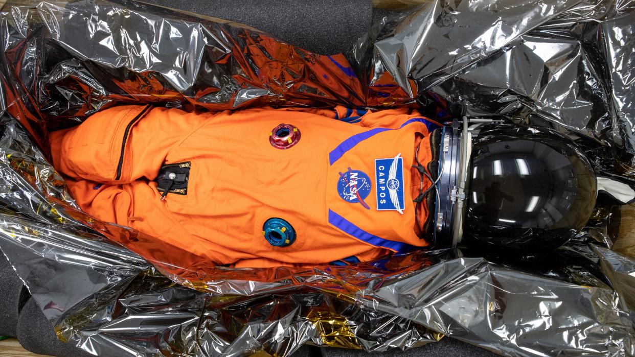  mannequin in a spacesuit and helmet lying in packing tape 