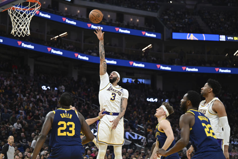 Golden State Warriors forwards Draymond Green (23) and Andrew Wiggins (22) watch as Los Angeles Lakers forward Anthony Davis (3) shoots during the first half of an NBA basketball game Saturday, Jan. 27, 2024, in San Francisco. (AP Photo/Nic Coury)