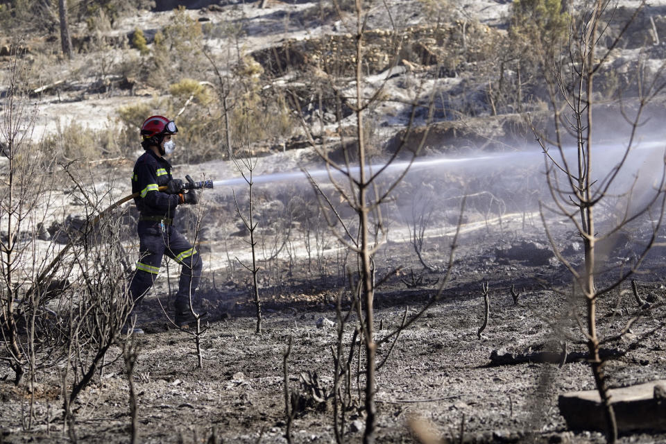 Firefighters try to extinguish a forest fire in Fuente la Reina, Castellon de la Plana, Spain, March 29, 2023. A prolonged drought after a record-hot 2022 appears to have brought the wildfire season forward and Spanish officials are now bracing for more huge fires. (AP Photo/Alberto Saiz)