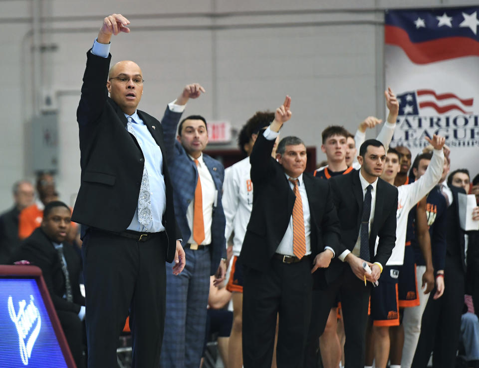 Bucknell coach Nathan Davis, left, and his bench signal for a call from the referee during the first half of an NCAA college basketball game against Colgate for the championship of the Patriot League men's tournament in Hamilton, N.Y., Wednesday, March 13, 2019. (AP Photo/Adrian Kraus)