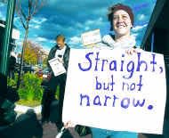 An LGBTQ+ ally carries a sign during a Pride march.