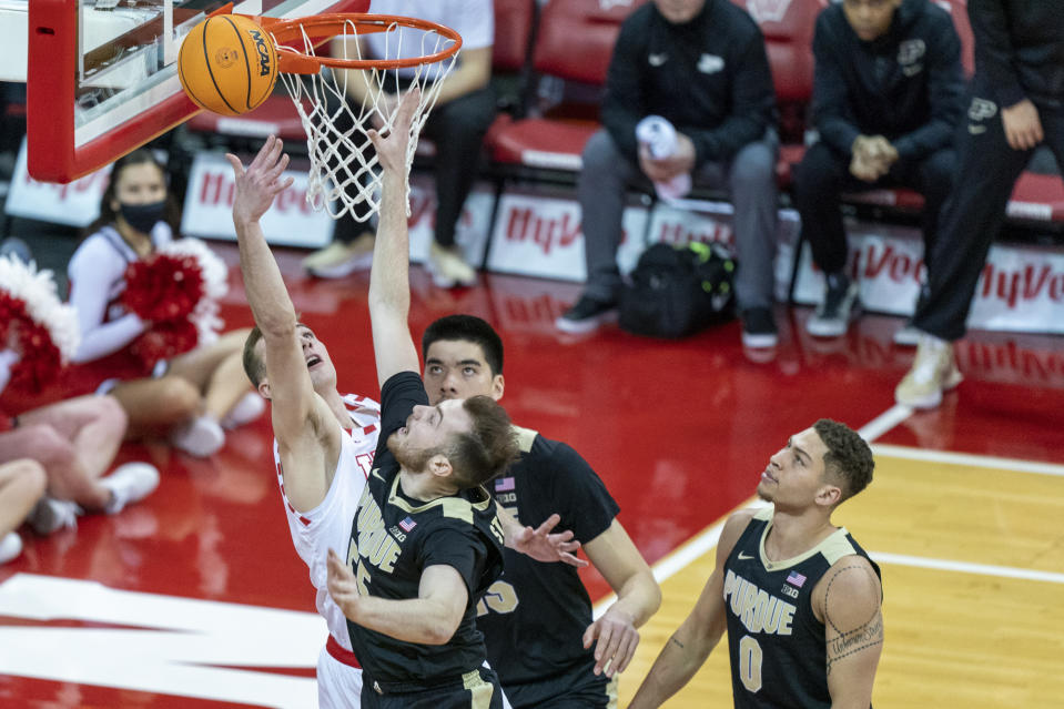 Wisconsin's Tyler Wahl, left, shoots against Purdue's Sasha Stefanovic, front, and Zach Edey, rear, during the first half of an NCAA college basketball game Tuesday, March 1, 2022, in Madison, Wis. (AP Photo/Andy Manis)