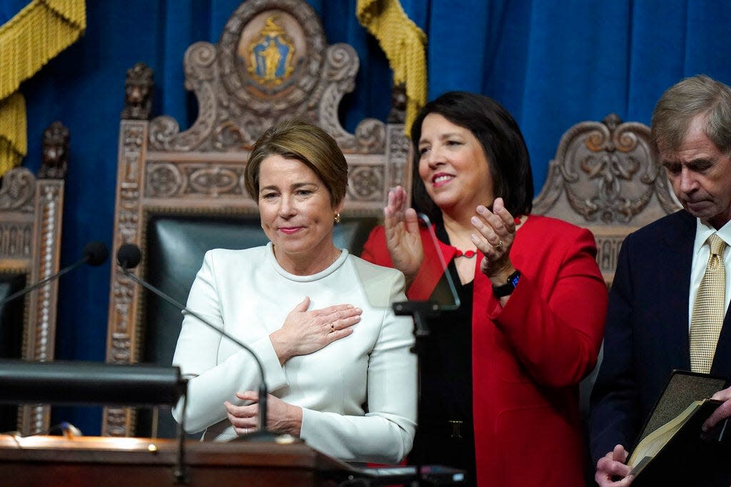 Gov. Maura Healey, left, acknowledges applause after being sworn into office as Kim Driscoll, center, the new lieutenant governor, and Secretary of the Commonwealth William Galvin look on.