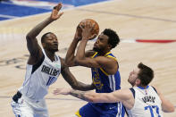 Golden State Warriors forward Andrew Wiggins (22) attempts a layup as Dallas Mavericks forward Dorian Finney-Smith (10) and guard Luka Doncic (77) defend during the second half of Game 4 of the NBA basketball playoffs Western Conference finals, Tuesday, May 24, 2022, in Dallas. (AP Photo/Tony Gutierrez)