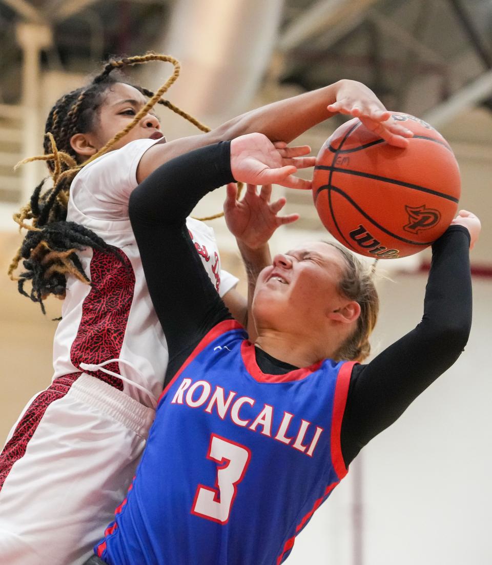 Roncalli Royals Sara Rosko (3) is blocked by Pike Red Devils guard Saniya Smith (1) on Tuesday, Nov. 14, 2023, during the game at Pike High School in Indianapolis.