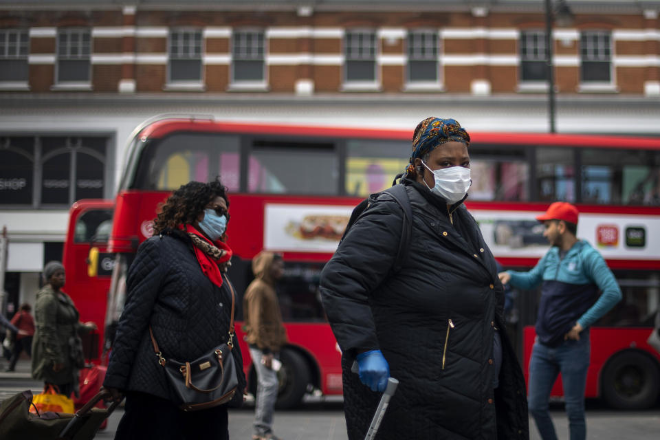 A woman in a protective face mask walks through Brixton Market in South London, as the UK continues in lockdown to help curb the spread of the coronavirus. (Photo by Victoria Jones/PA Images via Getty Images)