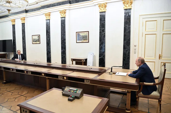 Russian President Vladimir Putin, right, meets at a distance with Russian Foreign Minister Sergey Lavrov, left, in Moscow on Feb. 14. 