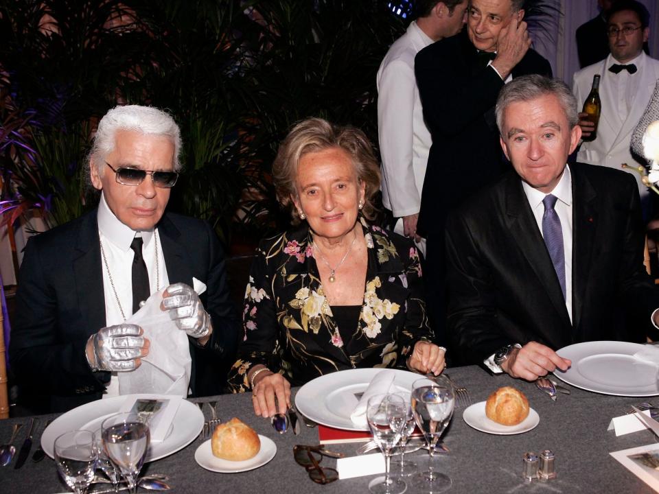 Karl Lagerfeld and Bernard Arnault sit at dinner table