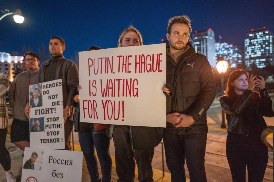 A sign alleges that Russian President Vladimir Putin has committed war crimes during a candlelight vigil in downtown Sacramento on Tuesday to mourn the loss of Alexei Navalny, the Russian opposition leader who died in an Arctic penal colony earlier this month. Renée C. Byer/rbyer@sacbee.com