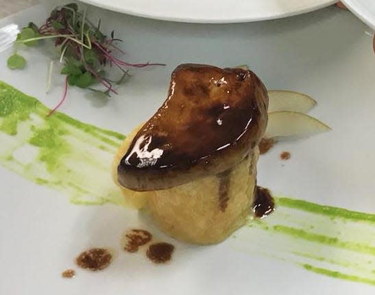 In an appetizer at Trevini, truffle risotto is layered with a parmesan crisp, seared foie gras and a port reduction.