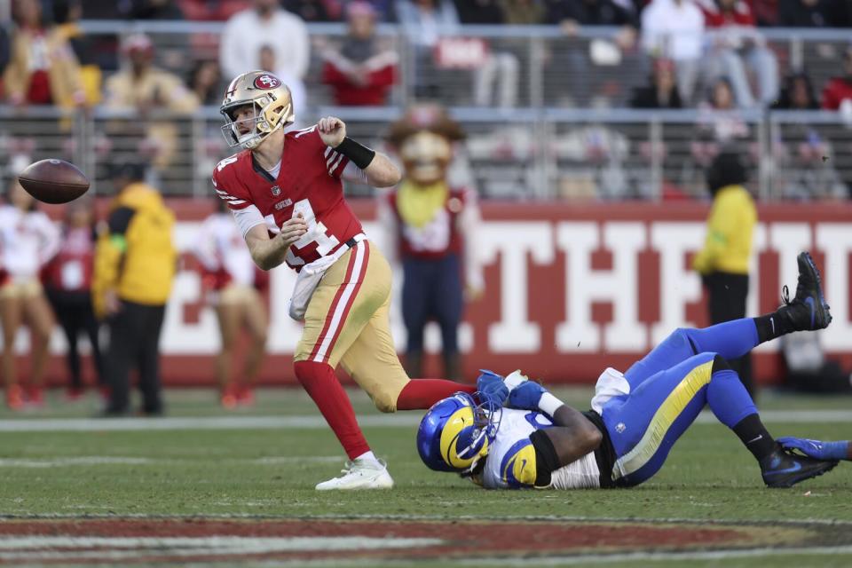 San Francisco 49ers quarterback Sam Darnold (14) fumbles in front of Desjuan Johnson.