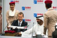 Airbus CEO Guillaume Faury, left, touches a model of an Airbus aircraft with Sheikh Ahmed bin Saeed Al Maktoum, the chairman and CEO of the Dubai-based long-haul carrier Emirates, at the Dubai Airshow in Dubai, United Arab Emirates, Monday, Nov. 18, 2019. The Dubai-based airline Emirates announced Monday a new order for 20 additional wide-body Airbus A350-900 planes in a deal worth $6.4 billion. This brings the airline's total order for the aircraft to 50 Airbus A350s costing $16 billion at list price. (AP Photo/Jon Gambrell)