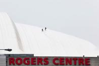 <p>Ice that fell from the CN Tower during a storm on April 16 damaged the Rogers Centre’s retractable roof, causing a MLB baseball game to be cancelled. Here, a crew works to repair some of the damage. (Photo from Andrew Francis Wallace/The Toronto Star/The Canadian Press) </p>